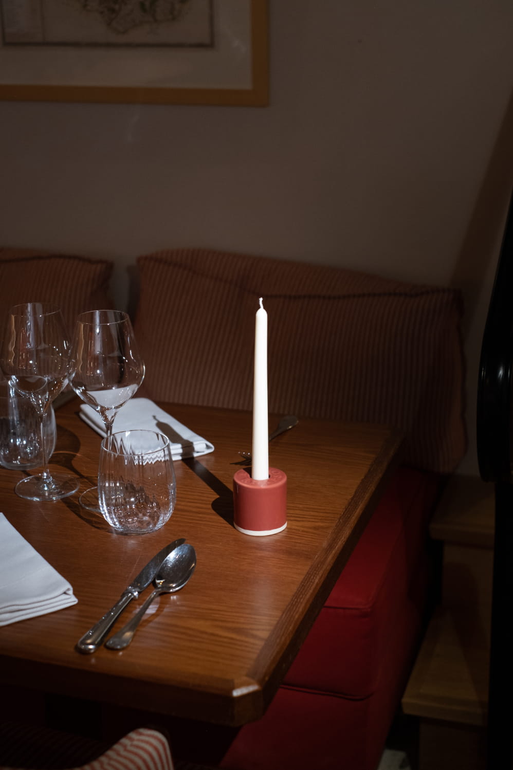 Bougeoir Véraison et sa chandelle blanche sur une table de restaurant dressée