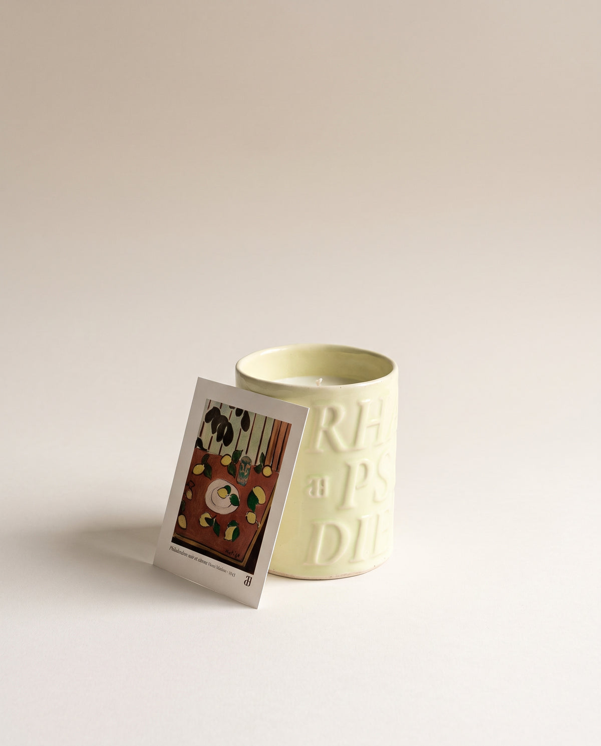 Bougie Capri dans sa céramique émaillée vert anis, avec le feuillet du tableau de Matisse « Philodendron noir et citrons »