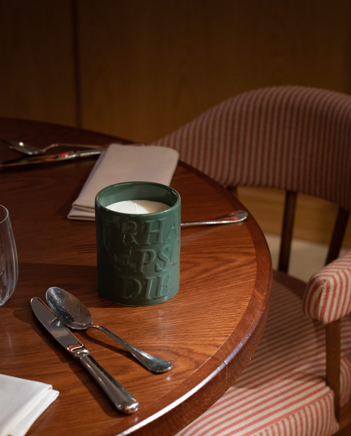 Bougie Mousse sur une table ronde en bois dressée pour le dîner
