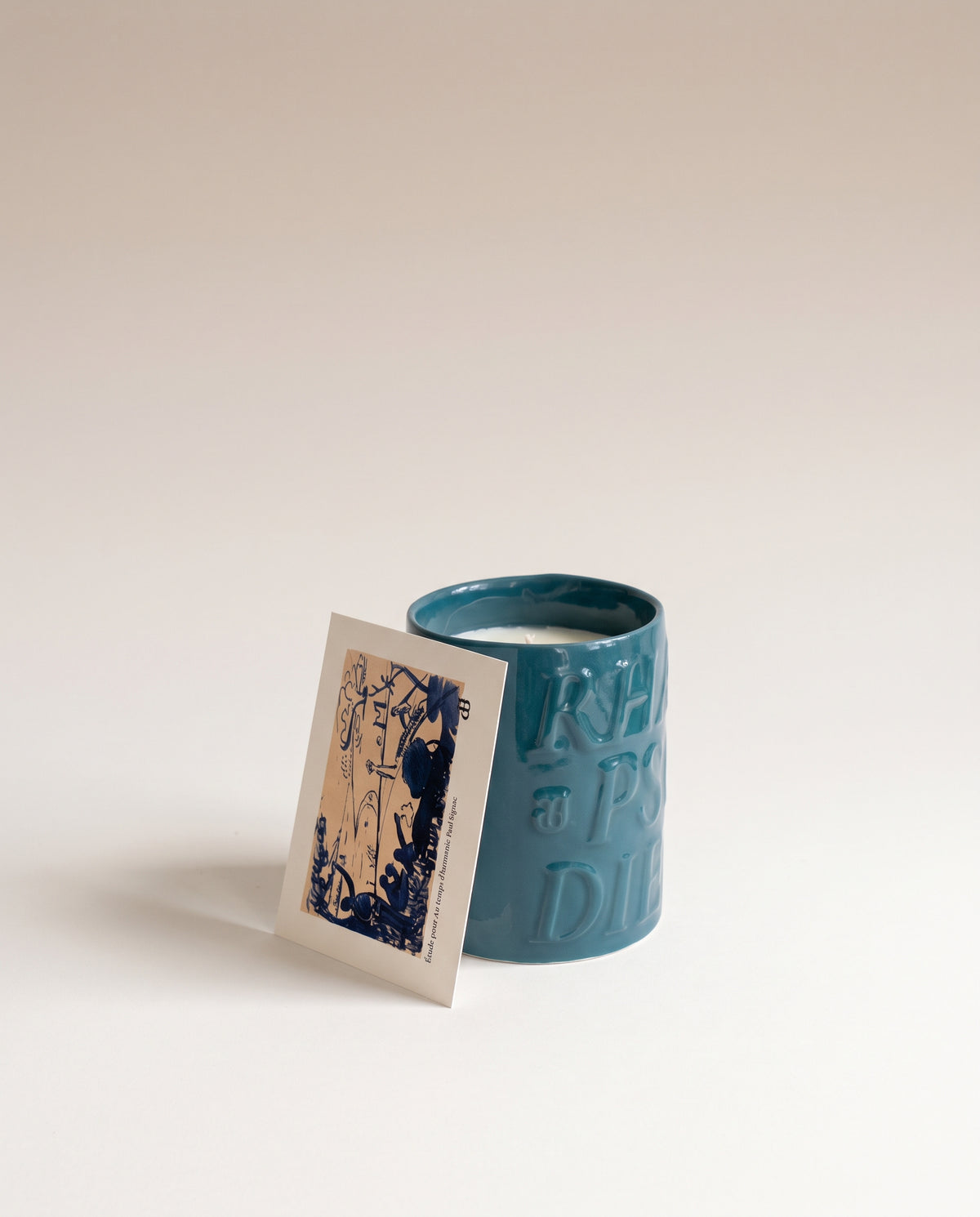 Bougie Riviera dans sa céramique émaillée bleu canard, avec le feuillet de l'étude de Paul Signac